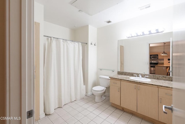 bathroom featuring toilet, vanity, walk in shower, and tile patterned flooring