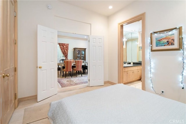 carpeted bedroom featuring a closet, sink, and connected bathroom