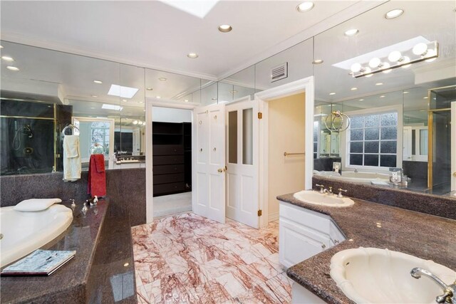 bathroom featuring vanity, a skylight, and a bath