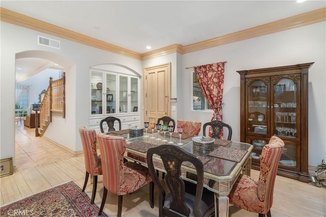 dining area featuring light hardwood / wood-style floors and crown molding