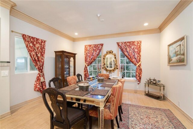 dining area with crown molding and light wood-type flooring