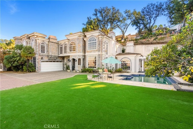 rear view of house with a yard, a patio, and a garage