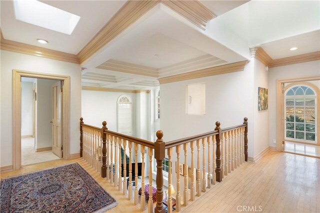 corridor featuring light hardwood / wood-style floors, beamed ceiling, coffered ceiling, a skylight, and ornamental molding