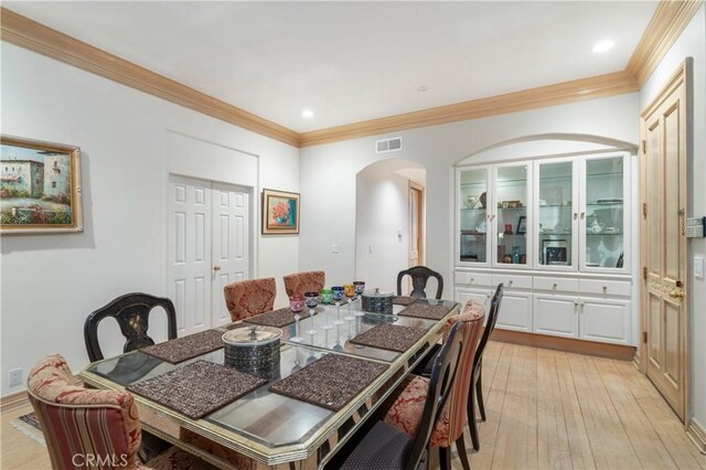 dining space featuring crown molding and light hardwood / wood-style floors