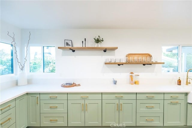 kitchen with open shelves, green cabinets, and light countertops