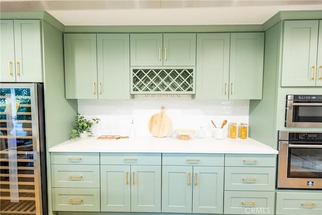 kitchen with beverage cooler, green cabinets, and light countertops