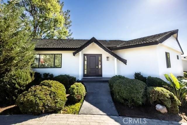 view of front of home with a tiled roof and stucco siding