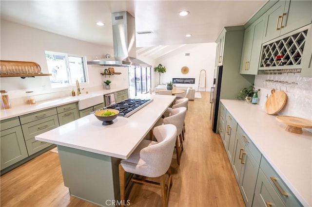 kitchen with island range hood, stainless steel appliances, and green cabinets