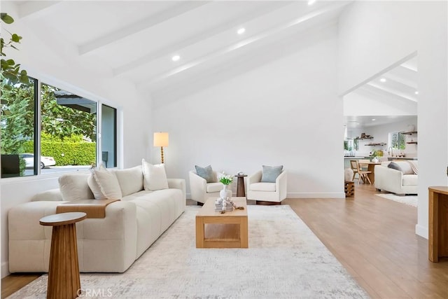 living room featuring vaulted ceiling with beams, light wood-style flooring, and recessed lighting