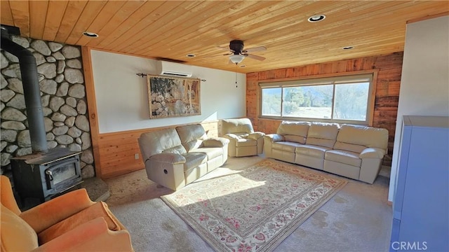 living room featuring wood ceiling, wooden walls, a wall unit AC, ceiling fan, and a wood stove