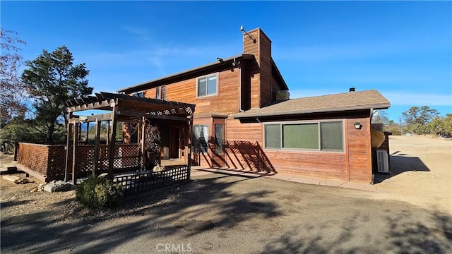 rear view of property with a patio and a pergola