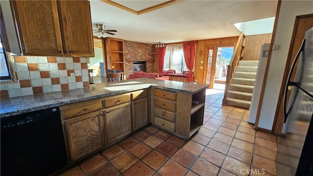 kitchen with kitchen peninsula, ceiling fan, black dishwasher, backsplash, and a fireplace