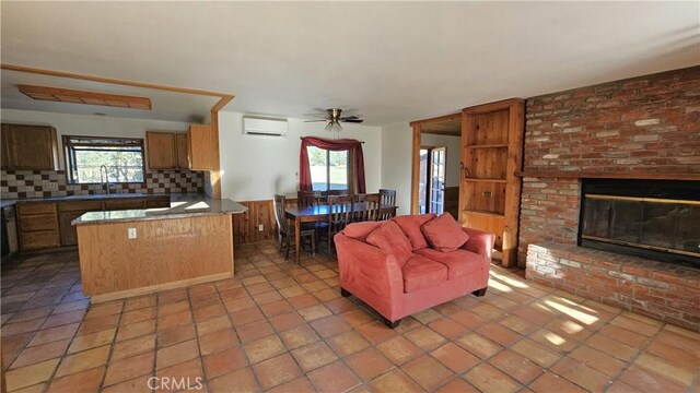 living room with a wall unit AC, ceiling fan, a wealth of natural light, and sink