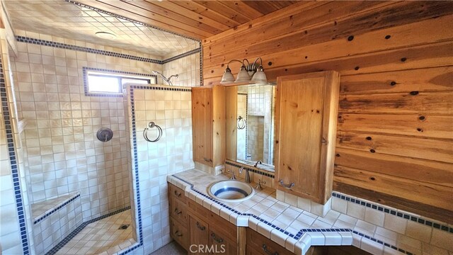 bathroom with walk in shower, sink, and wood walls