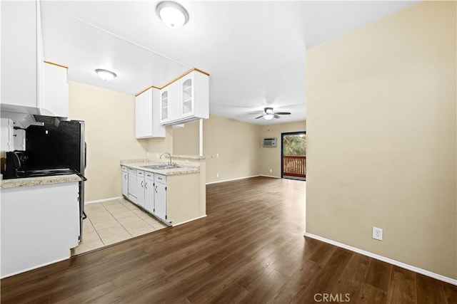 kitchen featuring ceiling fan, white cabinetry, light hardwood / wood-style floors, and sink