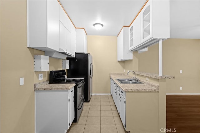 kitchen featuring kitchen peninsula, sink, black electric range oven, white cabinetry, and light tile patterned floors