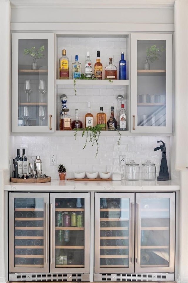 bar featuring decorative backsplash, beverage cooler, and a dry bar