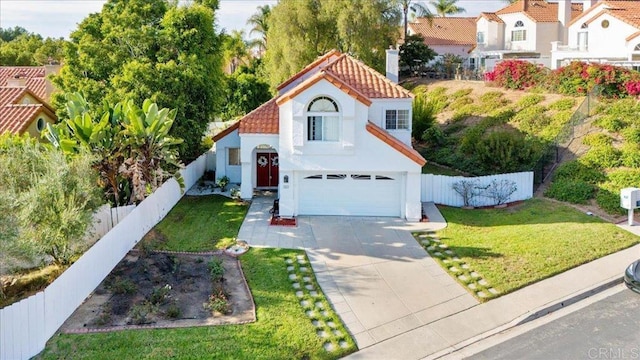 mediterranean / spanish-style home with a garage and a front lawn