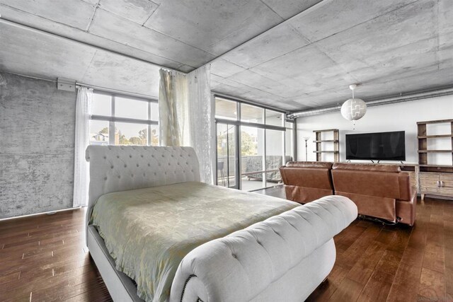 bedroom with a wall of windows and dark wood-type flooring