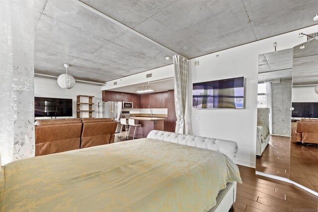 bedroom featuring dark hardwood / wood-style flooring and stainless steel refrigerator