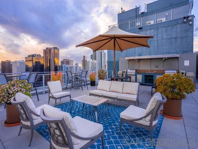 patio terrace at dusk featuring an outdoor kitchen, outdoor lounge area, and area for grilling