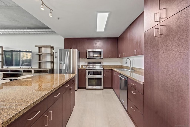 kitchen featuring sink, light stone counters, and stainless steel appliances