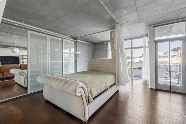 bedroom with access to exterior and dark wood-type flooring