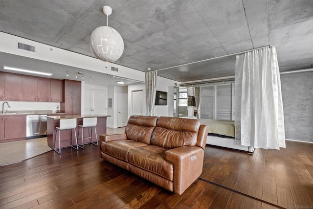 living room featuring sink, dark hardwood / wood-style floors, and a baseboard heating unit