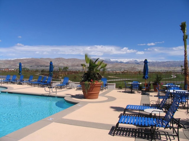 view of swimming pool with a mountain view and a patio area