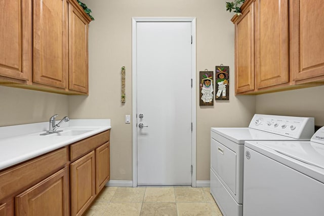 laundry area featuring sink, light tile patterned flooring, separate washer and dryer, and cabinets