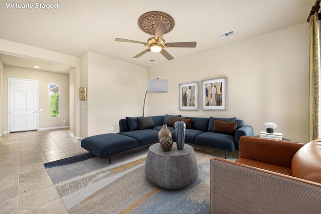 living room featuring light tile patterned floors and ceiling fan