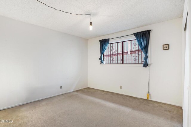 spare room featuring carpet and a textured ceiling