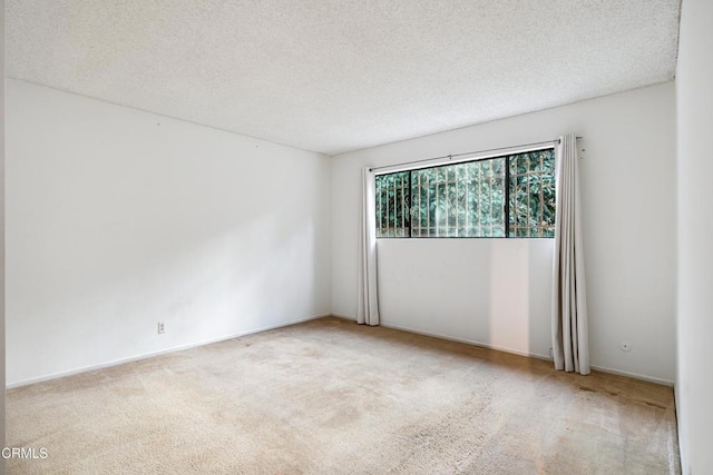 carpeted empty room with a textured ceiling