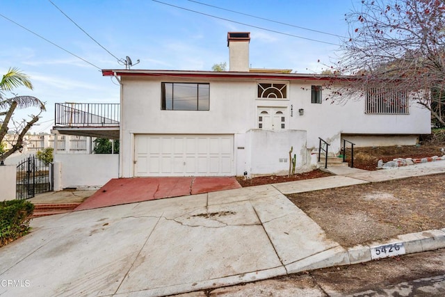 view of front of property featuring a balcony and a garage