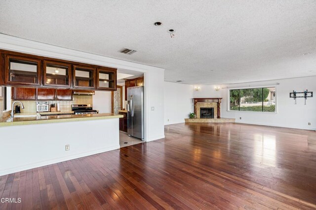 unfurnished living room featuring a textured ceiling, hardwood / wood-style floors, and sink