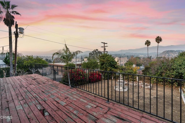 deck at dusk featuring a mountain view