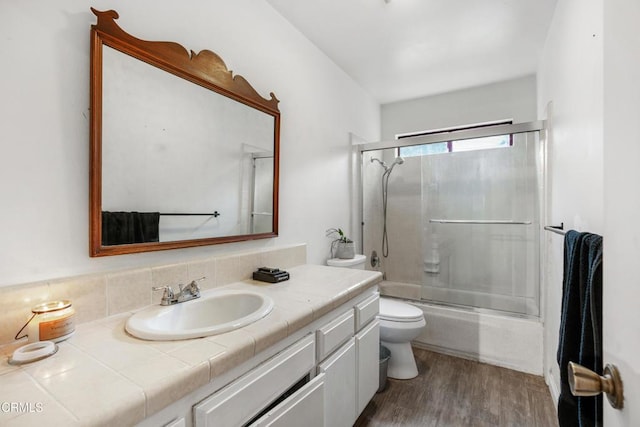 full bathroom with toilet, enclosed tub / shower combo, vanity, and hardwood / wood-style floors