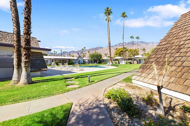 surrounding community featuring a mountain view, a yard, and a swimming pool