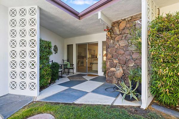 view of exterior entry with a patio