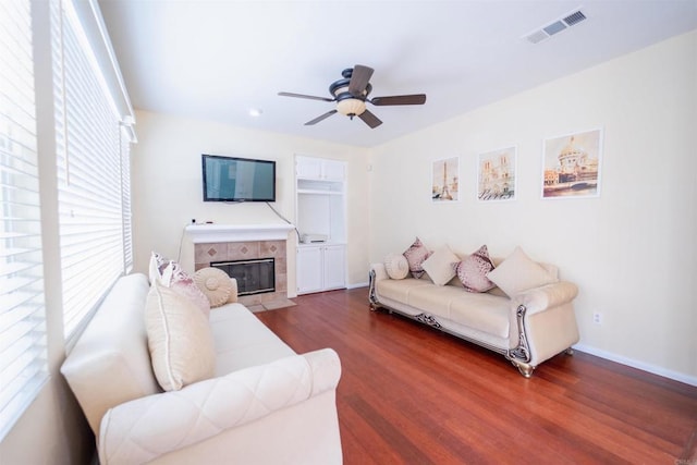 living room with a fireplace, ceiling fan, and dark hardwood / wood-style flooring