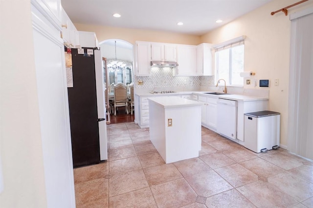 kitchen with refrigerator, white dishwasher, white cabinetry, and a kitchen island