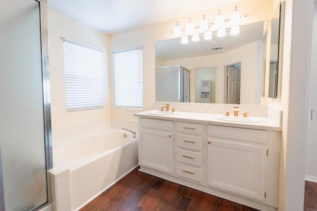 bathroom with wood-type flooring, vanity, and independent shower and bath