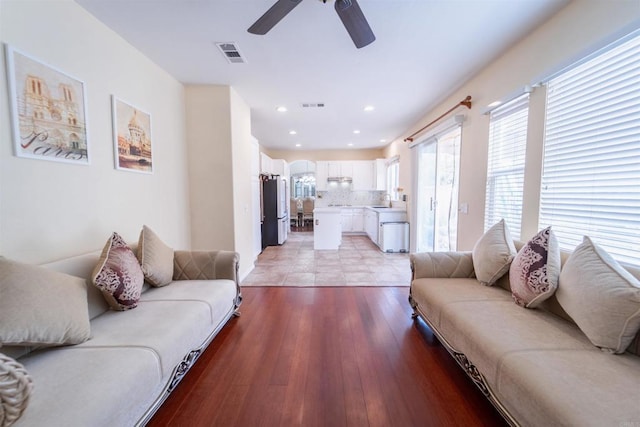 living room featuring light hardwood / wood-style floors, sink, and ceiling fan