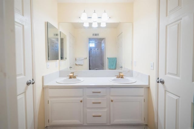 bathroom featuring a shower with shower door and vanity