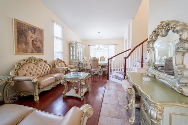 living room with vaulted ceiling, light tile patterned flooring, and a chandelier