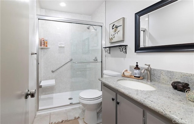 bathroom with toilet, vanity, tile patterned floors, and a shower with shower door