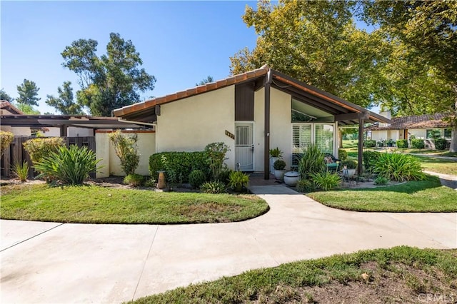 mid-century modern home featuring a front yard and stucco siding