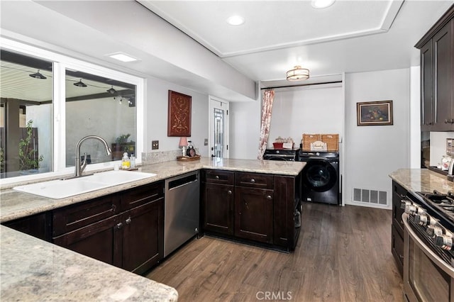 kitchen with washer / clothes dryer, kitchen peninsula, sink, stainless steel appliances, and dark hardwood / wood-style flooring