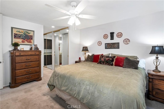 bedroom featuring ceiling fan, light colored carpet, and a closet