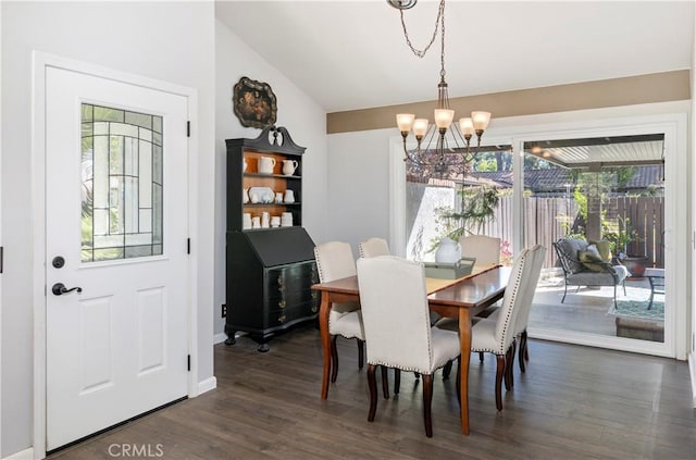 dining space featuring dark wood-type flooring, a wealth of natural light, lofted ceiling, and a notable chandelier